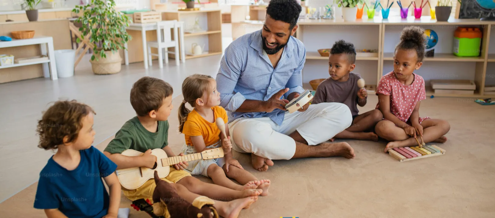 Photos showing five children, aged around five, sitting on the floor in a classroom or daycare with an instructor and holding small wooden musical instruments.