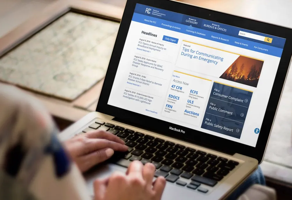 On a laptop, a user visits the modernized FCC.gov 