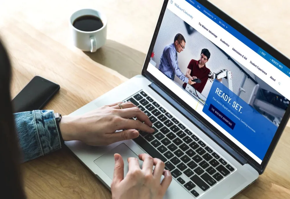 The Widener University homepage displayed on a laptop