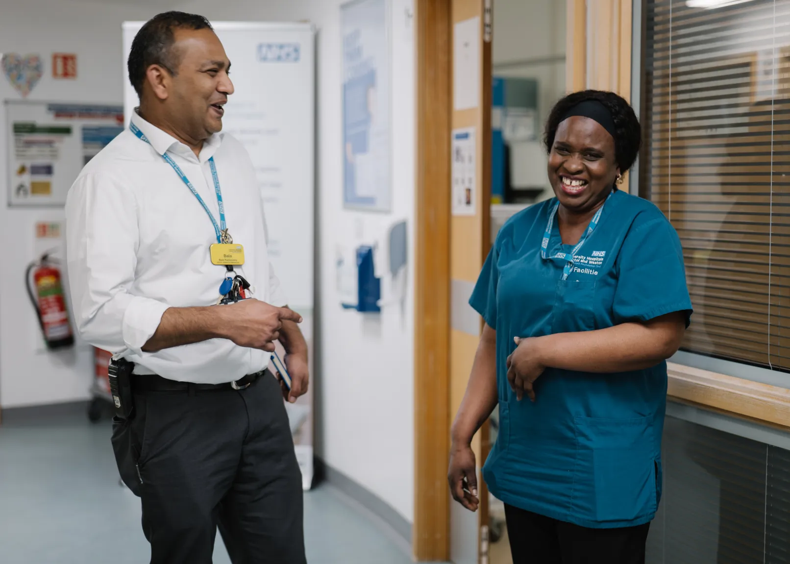 Two members of hospital staff talking together in a corridor