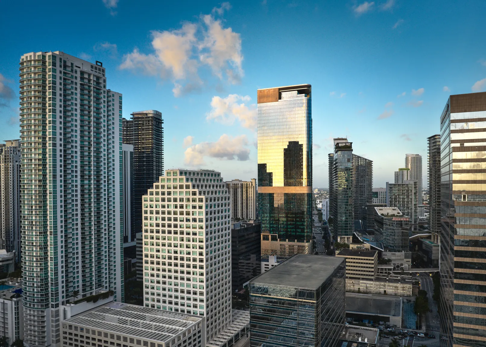 830 Brickell’s glass tower reflecting golden light above the surrounding Miami skyline
