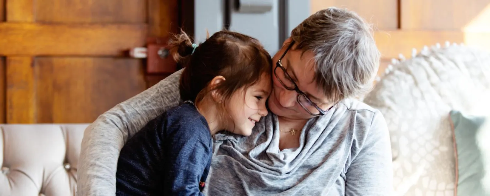 Older woman hugging a smiling young girl